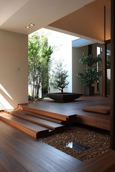 a bowl sitting on top of a wooden floor next to a planter and stairs