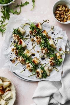 a white plate topped with food on top of a table next to bowls of vegetables