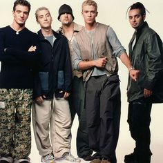 five young men standing together in front of a white background