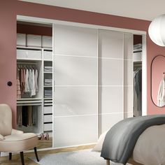 a bedroom with pink walls and white closets