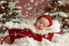 a baby sleeping in a sleigh with snow falling on it