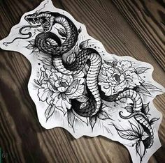 a drawing of a snake and flowers on a piece of white paper with black ink