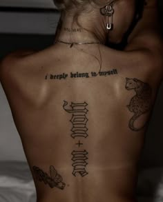 the back of a woman's body with tattoos on it