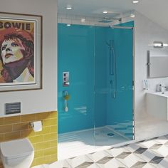 a bathroom with yellow and white tiles on the floor, blue glass shower stall door