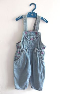 VINTAGE 1980's, very cute dungarees / overalls, heavyweight cotton denim fabric, purple buttons and overstiching, numerous pockets, elasticaterd waist at the back, cute patterned lining at the top, made in Europe. Estimated size 18 months  Vintage condition level 5, new old stock ( washed once ) We assess the condition of our vintage items on a scale from 0 to 5. Level 5 corresponds to an almost new vintage condition. Any defects are systematically reported. Even though in very good condition, v Dark Wash Buttoned Cotton Denim Jumpsuit, Vintage Cotton Denim Jumpsuit With Button Closure, Cotton Bib Front Overalls With Button Closure, Cute Cotton Shortalls With Pockets, Vintage Denim Blue Cotton Shortalls, Vintage Blue Cotton Shortalls, Cotton Overalls With Button Closure, Blue Vintage Cotton Shortalls, Retro Bib Front Cotton Jeans