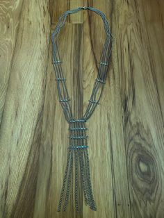 "This is a really cool long necklace! 4 chains run alongside each other and have a 3-bead long \"joint\" at 3 sections roughly 2\" apart. Then at the base of the necklace there's beaded joints spaced more tightly together to create the illusion of a pendant of sorts. And 7 chains hanging side by side below the jointed area. It's simple and unique at the same time! Can definitely be dressed up, but is great for casual wear and catches the eye. Perfect for special occasions! Long and non-adjustable, totaling roughly 16\" to the very bottom." Long Metal Layered Necklace With Chain, Metal Double Strand Beaded Chain Necklace, Metal Beaded Chain Necklaces For Layering, Metal Beaded Chain Necklace For Layering, Multi-strand Metal Layered Necklace With Adjustable Chain, Metal Layered Necklace With Adjustable Chain, Silver Multi-strand Beaded Chain Necklace, Long Silver Chain Necklace, Metal Beaded Chain Jewelry For Layering