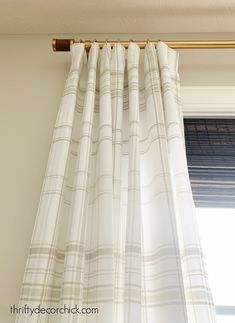 the curtain is hanging on the rod in front of the window with curtains pulled back