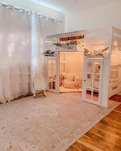 a white loft bed sitting on top of a wooden floor next to a living room filled with furniture