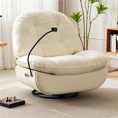 a living room with a white chair and a plant in the corner on the floor