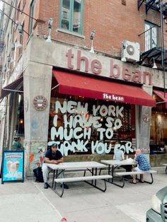 two men sitting on benches in front of the bean new york hights so much to thank you for