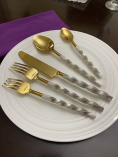 five forks and two spoons on a white plate