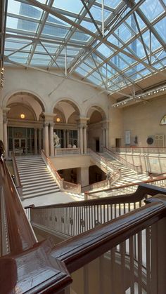 the inside of a large building with stairs and glass roof over looking another building that has multiple levels