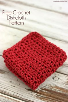 a red crochet dishcloth sitting on top of a wooden table