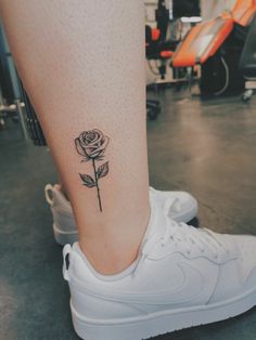 a woman's foot with a rose tattoo on the side of her left leg