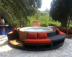 an outdoor hot tub surrounded by furniture and trees