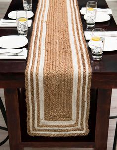 the table is set with plates and glasses on it, along with an empty place mat