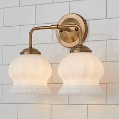 two light bathroom fixture with white glass shades on the back wall and bottom half of it