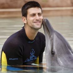 a man is kissing a dolphin in the water