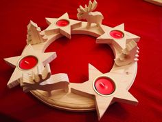 a candle holder made out of wood with red candles in the shape of stars on it