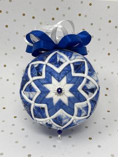 a blue and white ornament with a bow on it