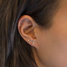 a woman wearing an ear piercing with two small stars on the back of her ear