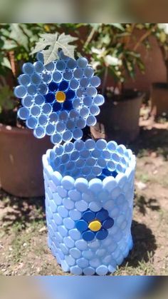 two vases made out of plastic cups sitting in the grass