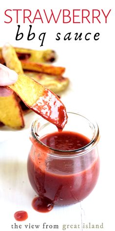 strawberry bbq sauce is being poured into a small glass jar