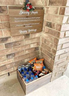 a wooden box filled with drinks next to a brick wall