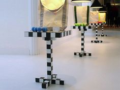 three lamps that are next to each other on a table with black and white squares