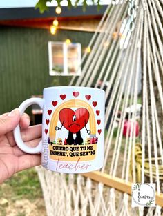 a person holding a coffee mug in front of a hammock with an image of a heart on it