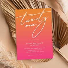 an orange and pink wedding card with the word twenty one on it next to some feathers