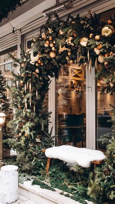 christmas wreaths and decorations are on display in front of a store window with large windows