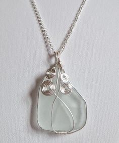 Real and natural white sea glass from the Tyrrhenian Sea, set with silver-plated jewelry wire. Optionally available with or without the 45 centimeter long 925 sterling silver chain. This white sea glass pendant has a particularly unusual shape and looks very interesting as a necklace pendant. It is not completely even on the back, which emphasizes its unique character in a positive way (see picture of back). It is relatively large: almost 3 cm long and about 2.5 cm wide without the setting and w Silver Sea Glass Necklace With Wire Wrapped Detail, Wire Wrapped Silver Sea Glass Necklaces, Wire Wrapped Silver Necklace With Sea Glass, Silver Wire-wrapped Necklace With Recycled Glass, Silver Wire Wrapped Necklace With Recycled Glass, Wire Wrapped Silver Recycled Glass Jewelry, Wire Wrapped Silver Jewelry With Recycled Glass, White Sea Glass Jewelry Gift, White Sea Glass Necklace As A Gift