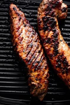 two steaks are cooking on the grill