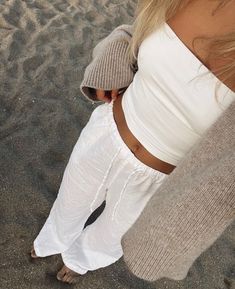 a woman standing on top of a sandy beach