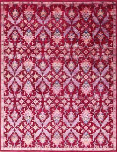 a red and pink rug with an intricate design on the center, surrounded by flowers