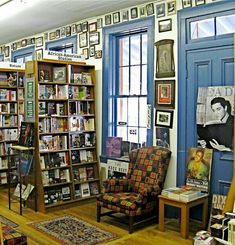 a room filled with furniture and bookshelves covered in pictures on the wall next to windows