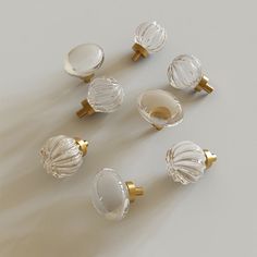 an assortment of glass knobs and pulls on a white surface