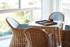 wicker chairs and table in front of large window