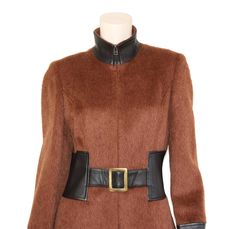 "This vintage alpaca blend coat is simply stunning. It's cut from a luxurious burnt sienna alpaca & wool blend fabric and has black leather trim. The coat also features a flattering tailored fit-n-flare silhouette and mod style elements for a true head turner. Collar can be worn zipped up as a turtleneck, or slightly unzipped for a more casual look. Coat is fully lined, has attached belt closure with brass hardware, and zips in front with a hidden brass zipper. Best fits size xs, small, or m Luxury Brown Wool Coat For Fall, Wool Coat For Evening Wear In Fall, Tailored Wool Coat For Evening In Fall, Fitted Wool Coat For Winter Evenings, Evening Wool Coat For Fall, Fitted Brown Wool Coat For Fall, Fitted Brown Wool Coat, Designer Tailored Wool Coat For Fall, Fitted Luxury Brown Outerwear