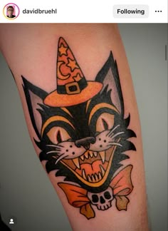 a cat with a witches hat on it's head is shown in this tattoo