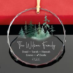 a glass ornament with the words, the wisconsin family and trees on it