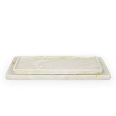 a white tray with gold trimmings on the edge and bottom, sitting on a white surface