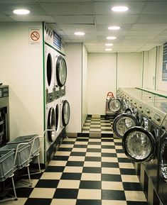 a row of washers sitting next to each other in a laundroom with checkered flooring