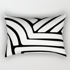 a black and white rectangular pillow with an abstract design on the front, featuring wavy lines