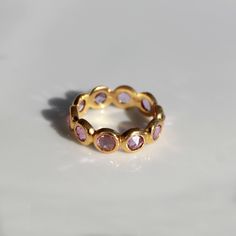 This ring with beautiful Natural sapphires, set in 18K Solid Gold. It is a ring perfect for any gifting occasions for your loved ones. Purchase the perfect gift for your mom, wife, grand mom, daughter, girlfriend, and fiancee. This ring, due to its design, can also be stacked easily with other rings. -Material - 18K Solid Yellow Gold -Gemstone - Natural pink Sapphire -Gemstone weight - 3.020 ct -Gross weight - 4.0 grams -Band Width - 5.25 mm Pink sapphires are recognized as having a variety of m Gold Stackable Rings With Sapphire Bezel Setting, Gold Sapphire Stackable Rings With Bezel Setting, Gold Stackable Sapphire Birthstone Ring, Gold Sapphire Stackable Birthstone Ring, Gold Sapphire Crystal Ring, Gold Amethyst Ring With Sapphire For Anniversary, Sapphire Eternity Band Gift, Gold Pink Sapphire Ring For Wedding, Wedding Gold Pink Sapphire Ring