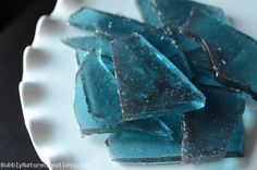 pieces of blue glass sitting on top of a white plate