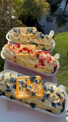 three trays filled with cake on top of a table