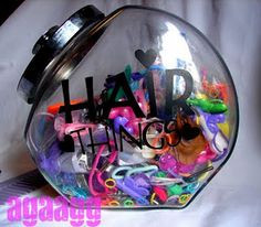 a glass jar filled with lots of different types of toys and letters that spell out the word hair