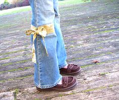 a person wearing blue jeans and brown shoes with a yellow ribbon tied around their ankles